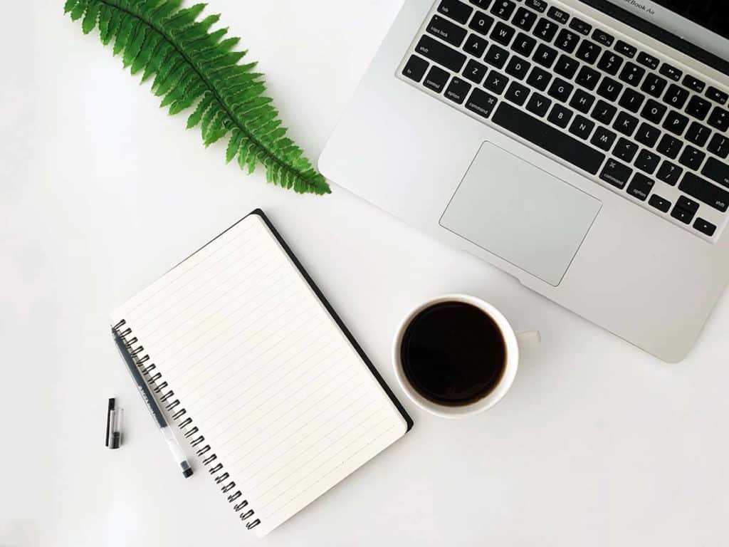 Spiral-bound notebook and a laptop