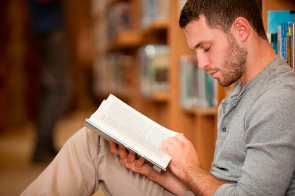 Man reading a book in a library