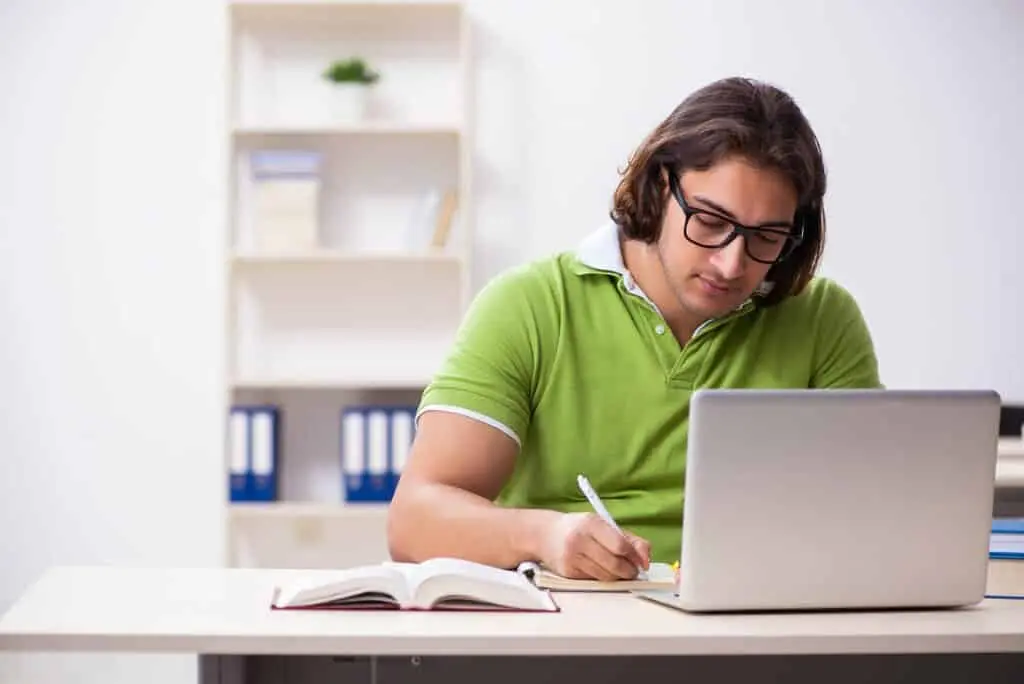 Young male student in the classroom studying