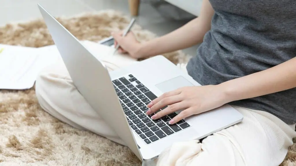 Asian woman taking notes in notebook while studying online in laptop at home, video chat, Online communication , Stay home, New normal, Covid-19 coronavirus, Social distancing, Learn online.