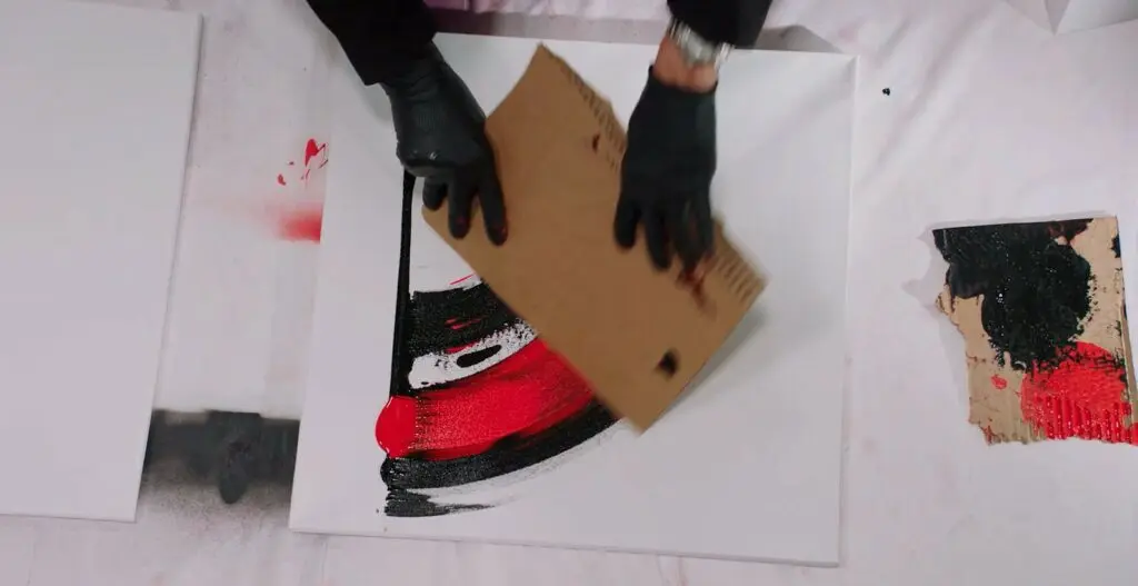Demonstrating the technique of using a piece of cardboard to smear spray paint