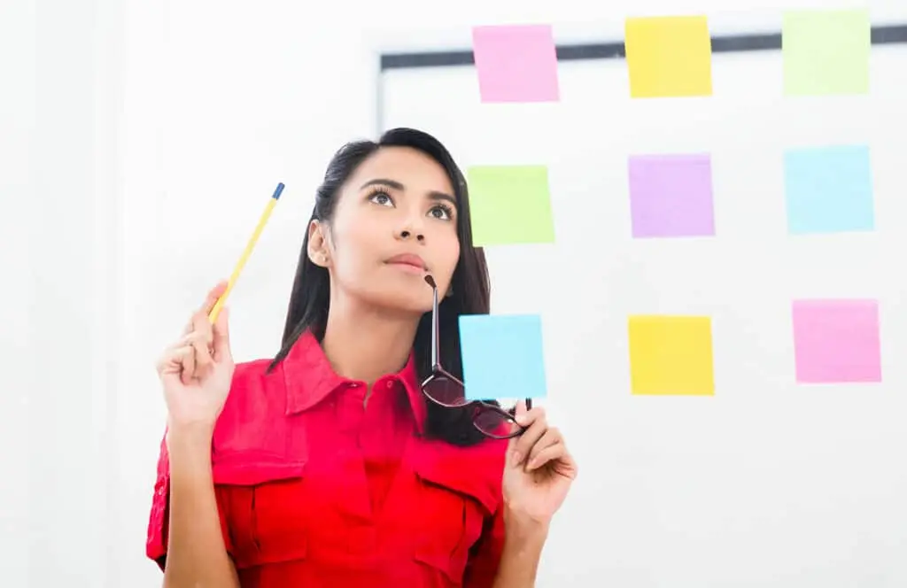 A woman with glasses watches the tasks at hand.