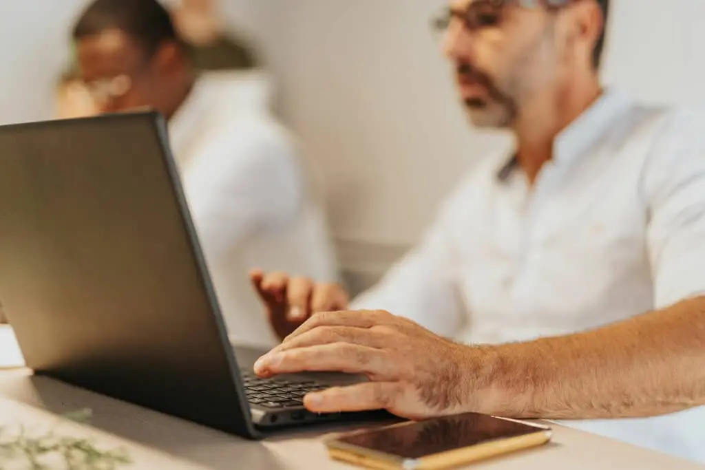 a man sits at his laptop and works